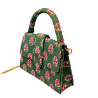 A structured green handbag with a pink and gold floral pattern, featuring a top handle, flap closure, and a gold chain strap, shown on a plain white background.