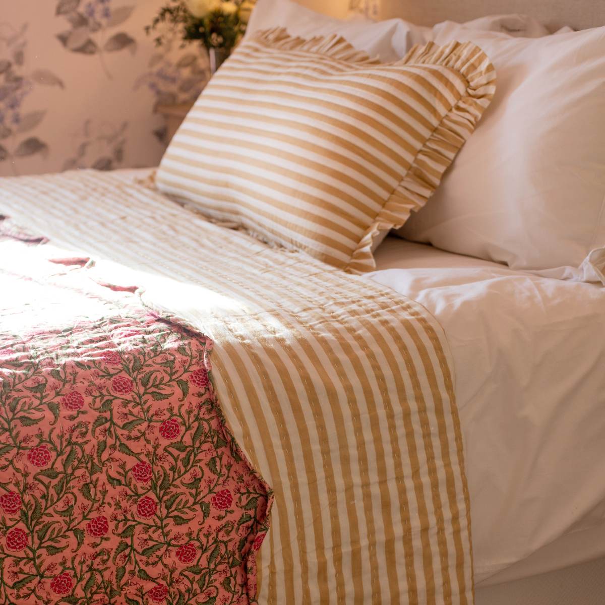 Bed with floral and striped bedding