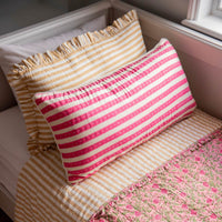 Striped pillows on a bed with floral blanket