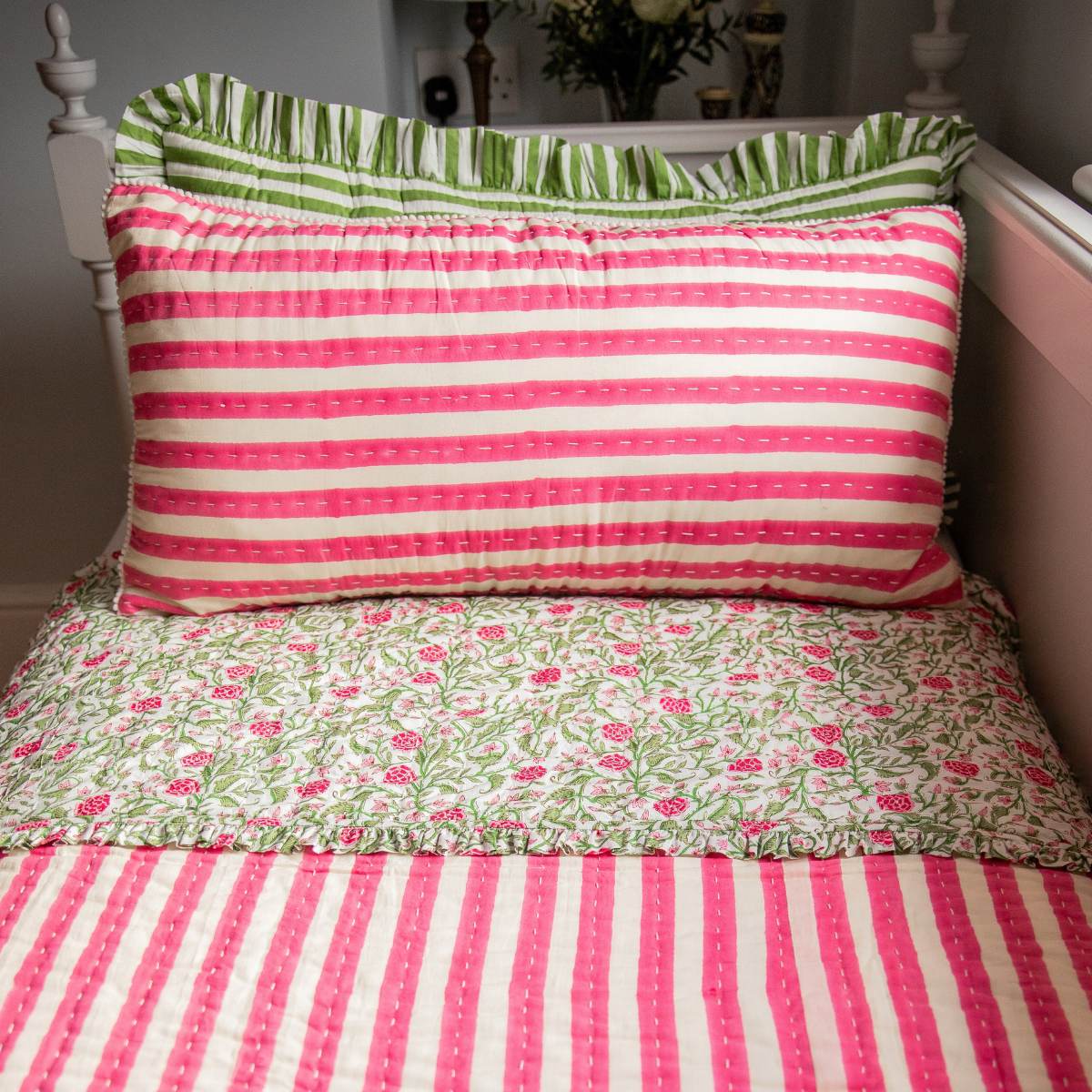 Striped and floral patterned bedding on a bed