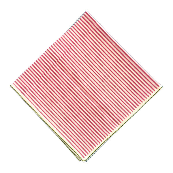 A square fabric napkin with thin hot pink and white vertical stripes, folded diagonally on a plain white background.