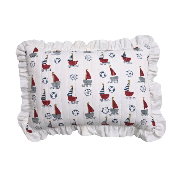 A rectangular ruffled pillow with a white fabric body printed with a nautical sailboat pattern in red, navy, and gray, finished with a ruffled edge.