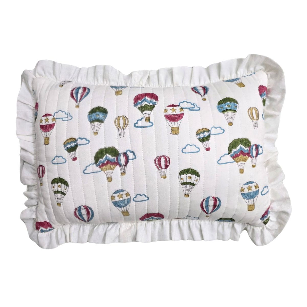 A square white pillow with a ruffled border, featuring an all-over print of colorful hot air balloons and clouds.