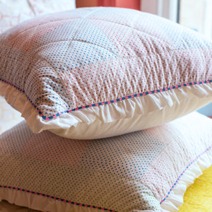 Textured pillows with decorative stitching on a soft background