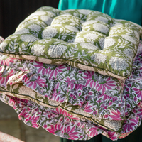 Stack of summer FARO blockprint seat pads in garden